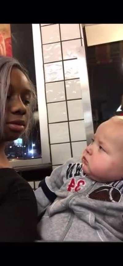 Baby stares at a woman then smirks