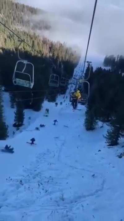 Snowboarder falls off ski lift and knocks down everyone