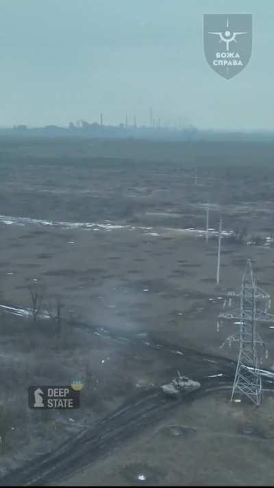 Drone perspective of a M1 Abrams firing at an enemy position 