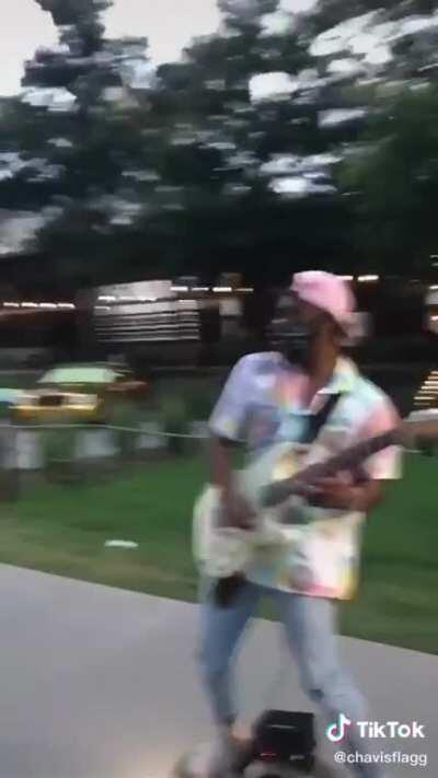 This guy shredding on his guitar while riding a one wheel