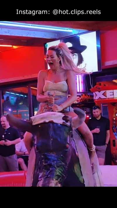 Blonde riding mechanical bull