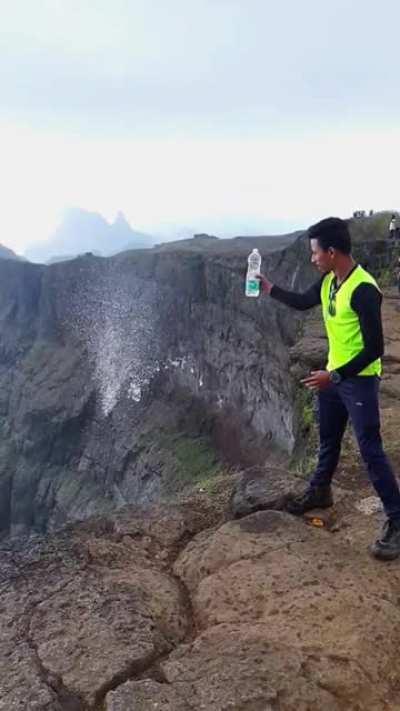 Pouring water, over a cliff, with high speed winds.