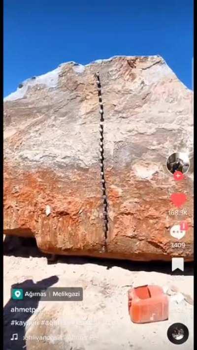 Splitting an enormous boulder by hand