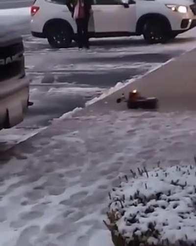 A toy plow truck clearing snow at a strip mall.

