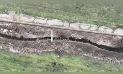 Russian soldier digging a trench almost takes out a FPV drone by throwing his shovel at it.