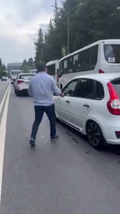 A passerby throws trash back into a litterbug's car