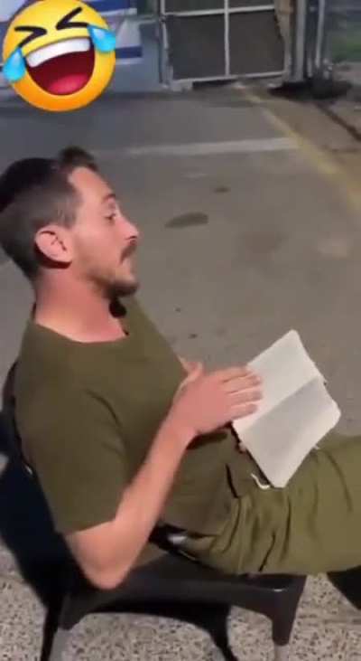 Israeli soldier reading a lesson from the talmud to chained Palestinian detainees at a checkpoint in an attempt to humiliate them