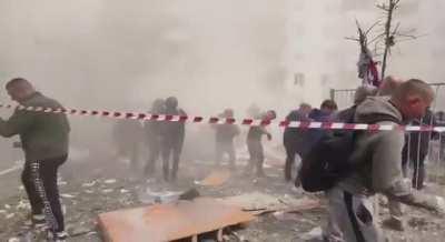 Onlookers scatter as more of the Belograd building collapses during rescue efforts. 