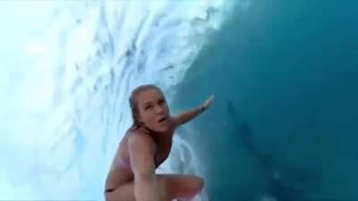 Riding a wave while holding a selfie stick