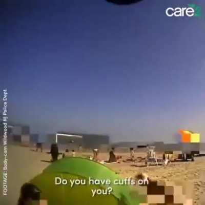 Police men beating down a woman on a beach because they were wrong