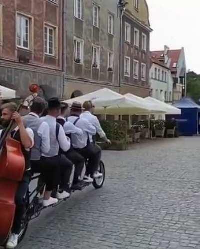 Music band in Poland playing on a bike riding through town