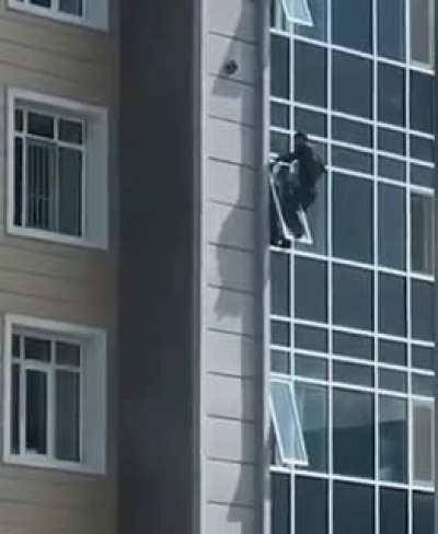 This man risks his life to save a toddler hanging from a window in Kazakhstan.