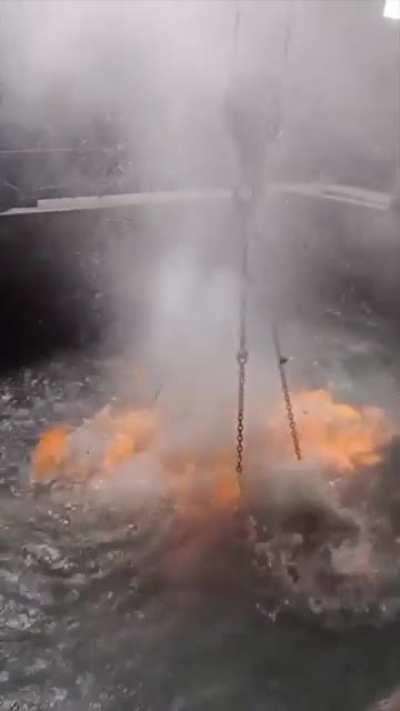 Lowering hot metal into water