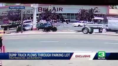 Dump truck plows through parking lot