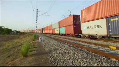 A double stacked container train on a curve on dedicated freight corridor, India