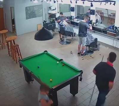 Kid casually does difficult shots on billiard