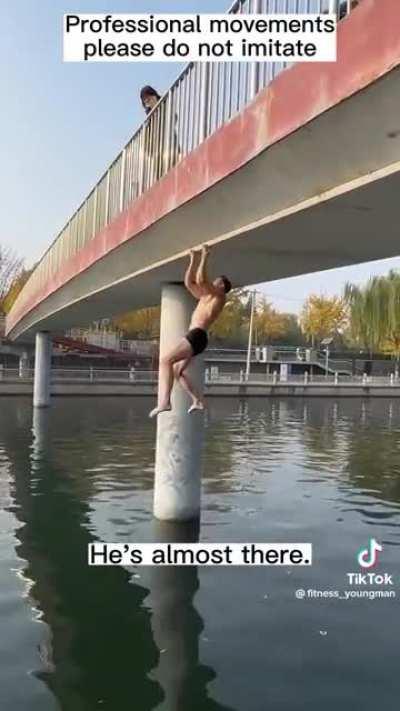 Man climbs bridge with his fingers