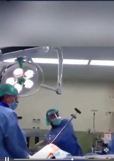 Orthopaedic surgeon removing nail from a femur