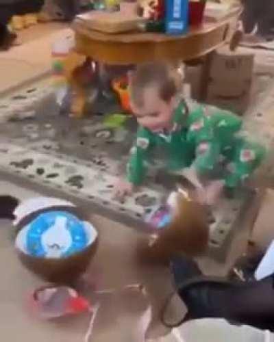 Little kid ground-stops Easter egg to get the goodies inside.