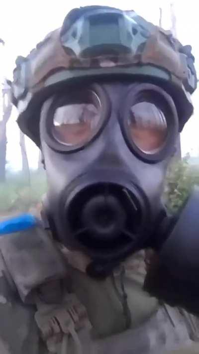 Colombian soldier wearing gas mask during alleged use of tear gas (or something similar) by the Russians against Ukrainian positions in the Kreminna forest, constant shelling around the position. July 2024