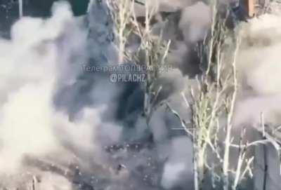 Two Russian soldiers throw two TM-62 anti-tank mines into a house collapsing the entire building