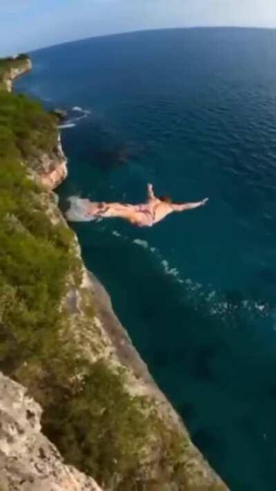 Skillful cameraman following a professional diver jump into the ocean