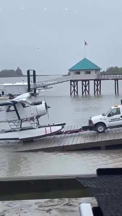 Half a truck towing a seaplane