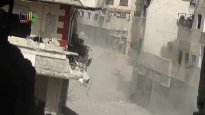 Syrian Armor moving through Daraya saturate potential anti-tank firing points with suppressive fire - 3/13/2013