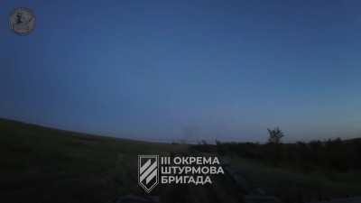 T-72 tank crew firing at Russian positions from a distance with the 125mm cannon to support Ukrainian infantry and then retreating while activating a smoke screen, Kharkiv region. 3rd Assault Brigade. Published on August 5, 2024.