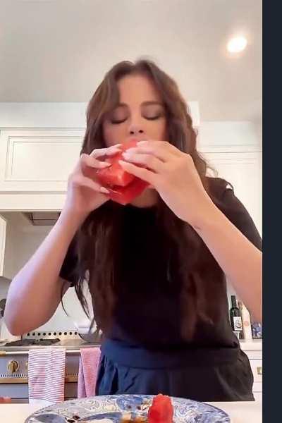 Selena eating a watermelon sandwich…