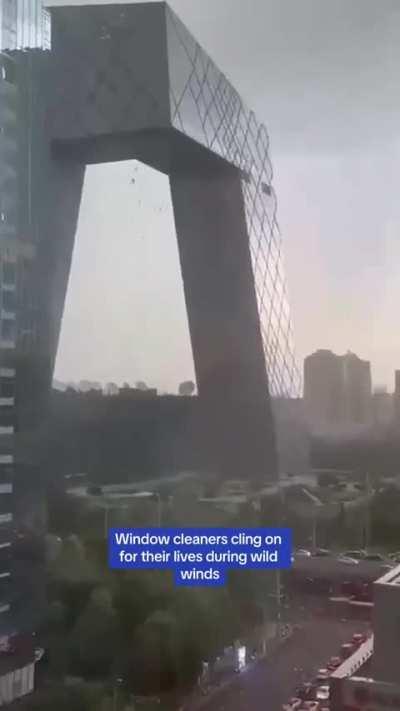 Window cleaners dangle from Beijing’s tallest building during intense winds 