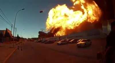 Burning warehouse explodes, sending a propane tank flying through the air.