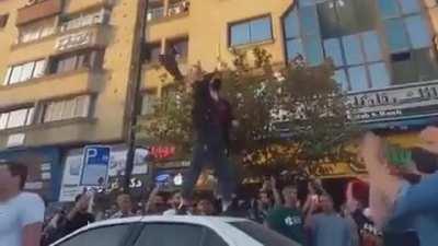 Women on a car takes off her hijab in front of Iranian police