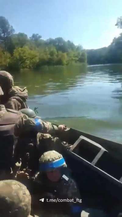 Ukrainian soldiers crossing a river in a boat, likely as part of amphibious operations in Kherson