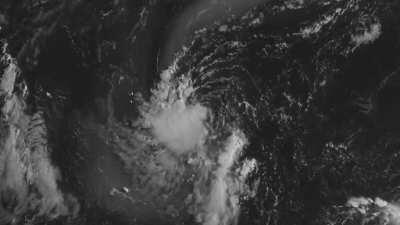 Ash clouds from the Nishinoshima volcano wrapping around the exposed circulation of 06W