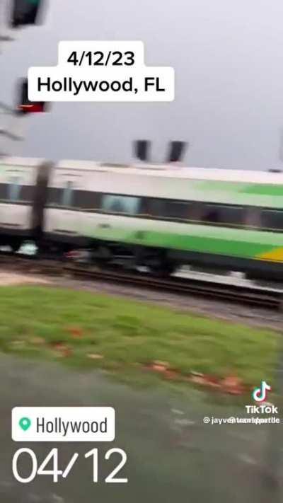 Truck carrying trailer full of cars is hit by train in Florida