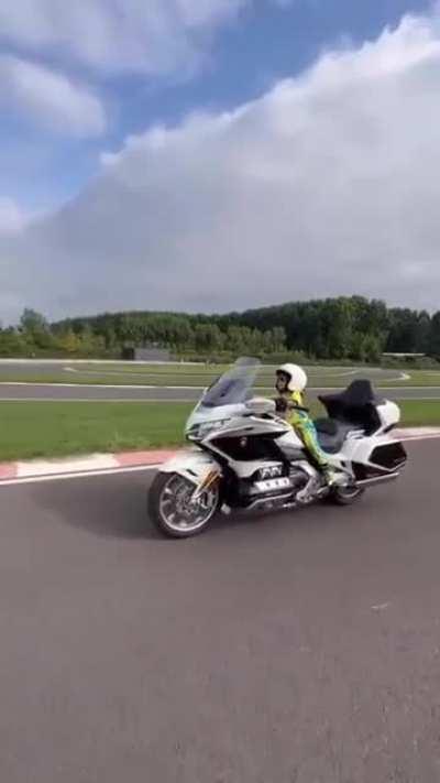 3- year old boy rides a Honda goldwing around a race track