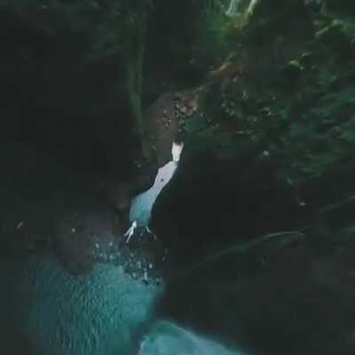 Incredible drone shot gliding down a waterfall