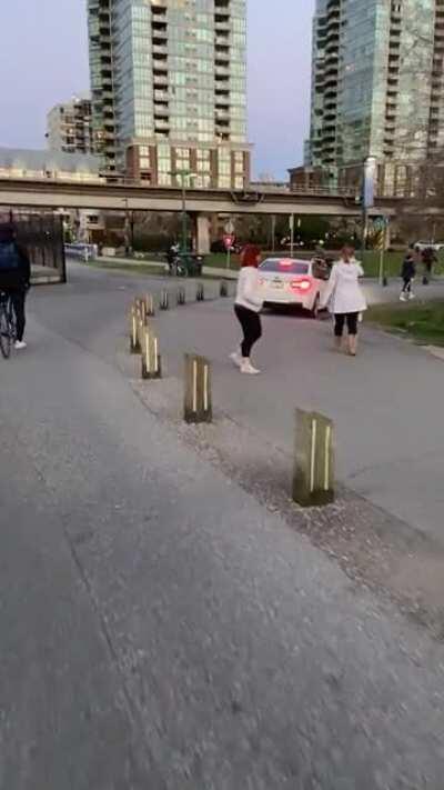 Person driving on the pedestrian path along the seawall at false creek