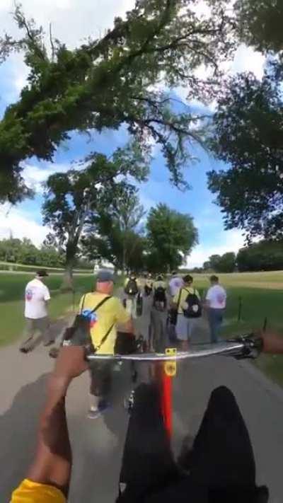 Cyclist wheelies through group of wheelchair users