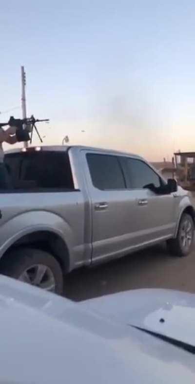 Narcotraficante shooting a fully automatic, belt-fed AR15 with a 100 round ammo box en un rancho de Sinaloa, México.