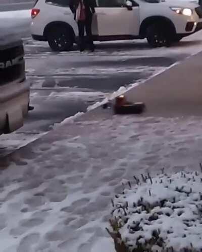 A toy plow truck clearing snow at a strip mall.