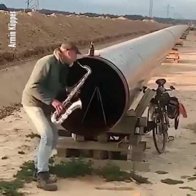 Playing saxophone into a long pipeline