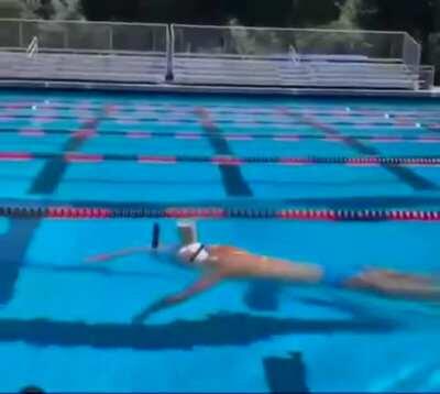 Olympic Swimmer Katie Ledecky balances a glass of chocolate milk on her head while swimming the entire length of the pool