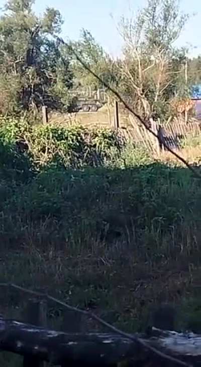 A local resident films the passage of a Ukrainian BTR-4E with a 