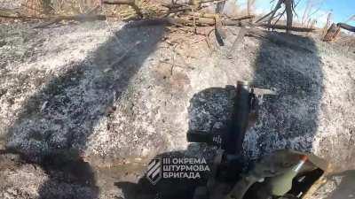 Soldiers from the 3rd Assault Brigade, with the support of an APC, storming Russian trench positions in the Bakhmut area