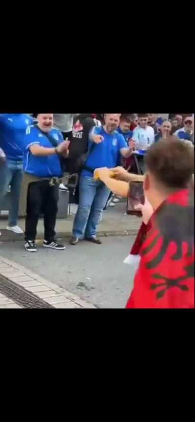 Albanians breaking spaghetti in front of Italian fans