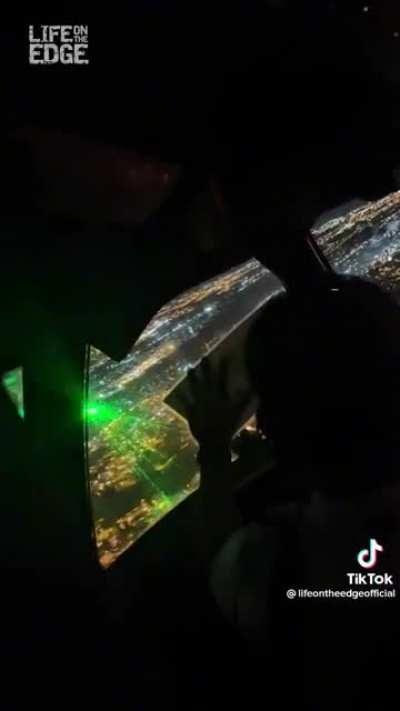 Pointing a laser at a plane.