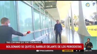 Brazil's president Bolsonaro, after testing positive for Cornavirus, takes off his mask during an interview to say he is fine