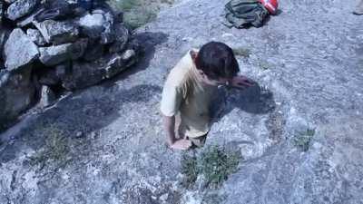 Man enters through this small entry to explore a cave